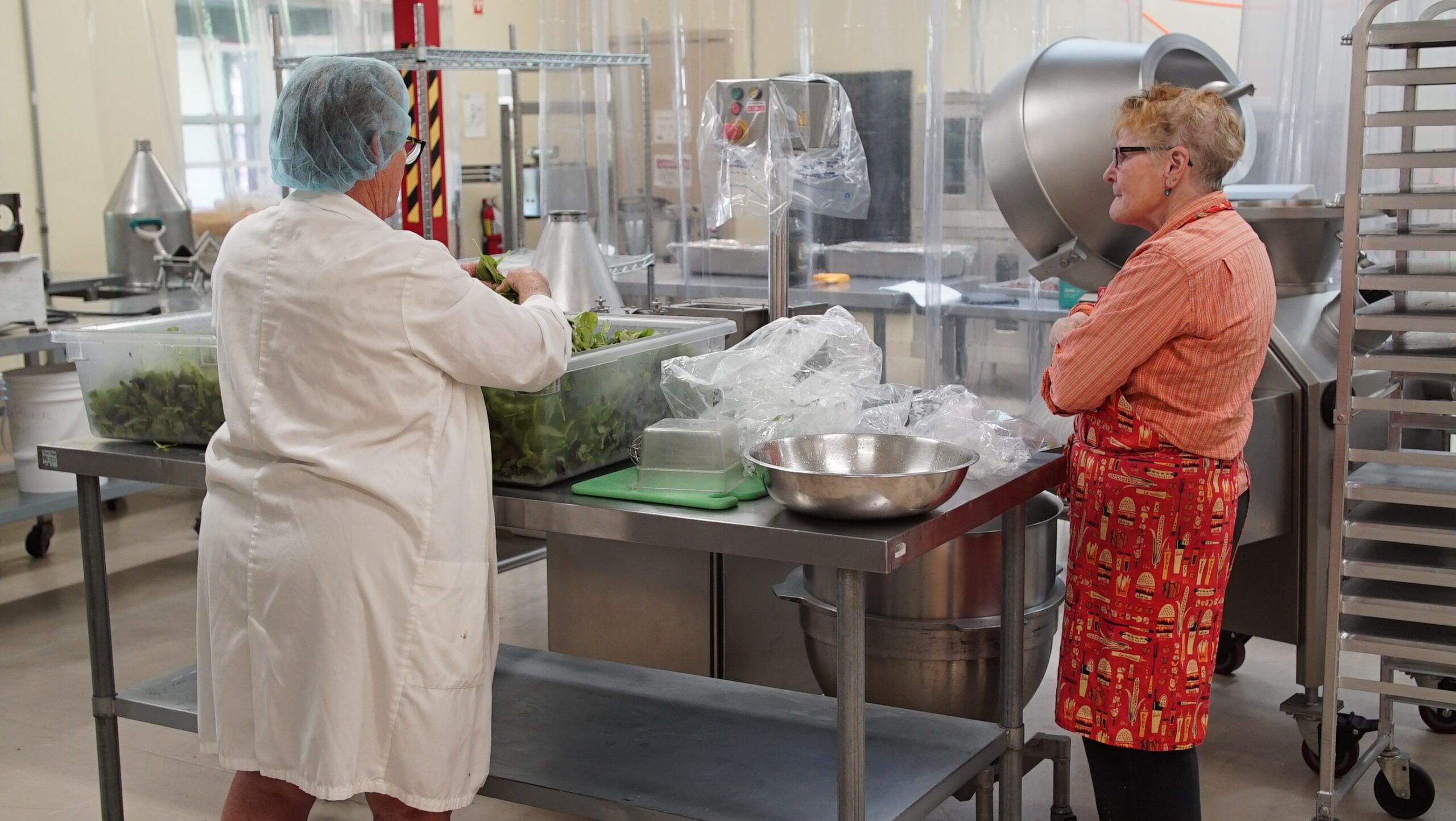 Two staff preparing fresh greens in the MMFEC commercial processing kitchen